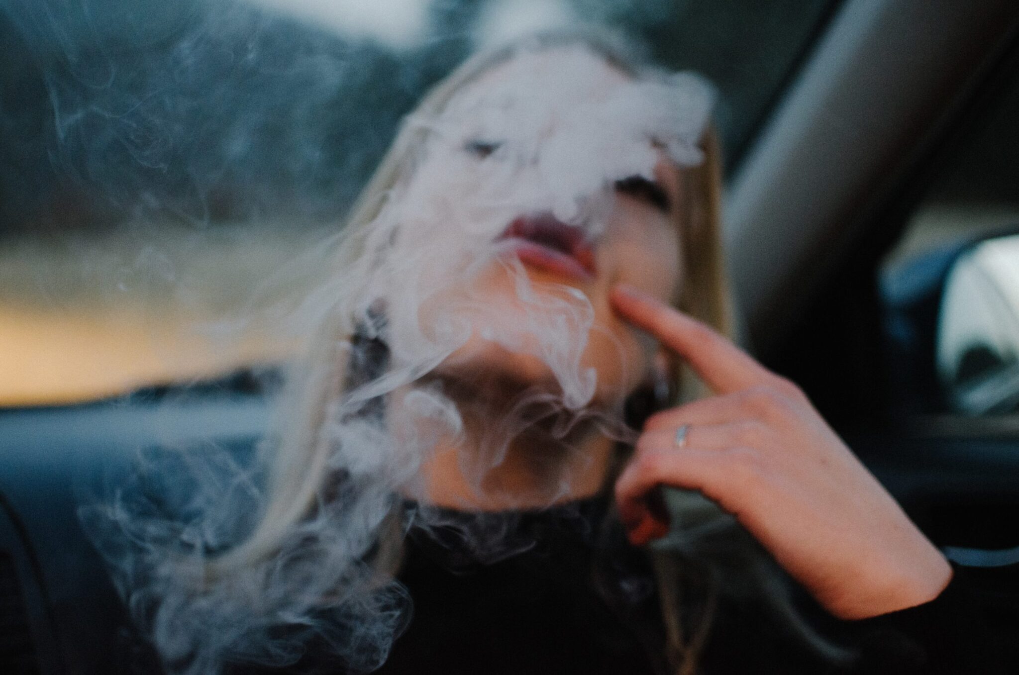 woman blowing smoke from cannabis